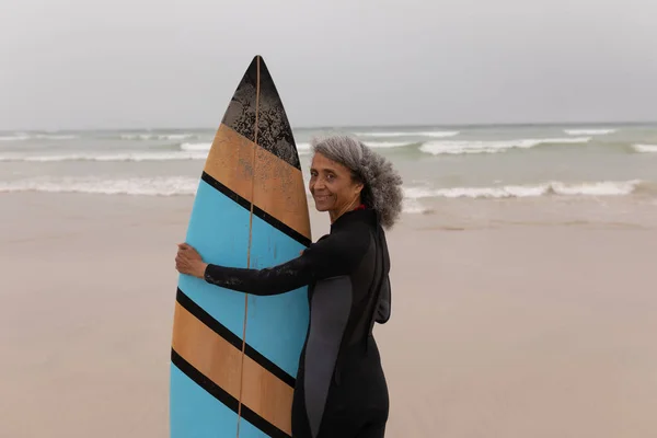 Side View Senior Female Surfer Standing Surfboard Looking Camera Beach — Stock Photo, Image