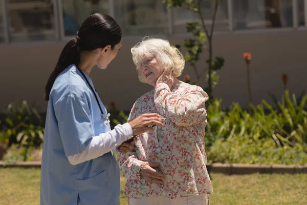 Side View Young Female Doctor Examining Senior Woman Garden Sunny — Stock Photo, Image