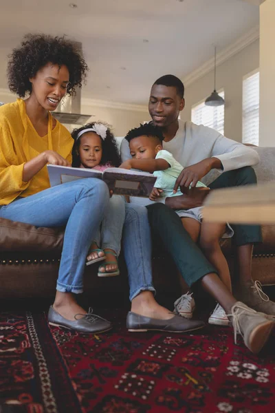 Framifrån Lyckliga African American Föräldrar Med Sina Söta Barn Läsa — Stockfoto