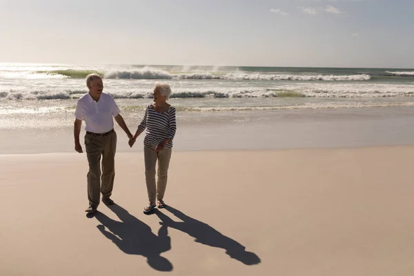 Вид Счастливую Пожилую Пару Держащуюся Руки Идущую Пляжу Солнечном Свете — стоковое фото