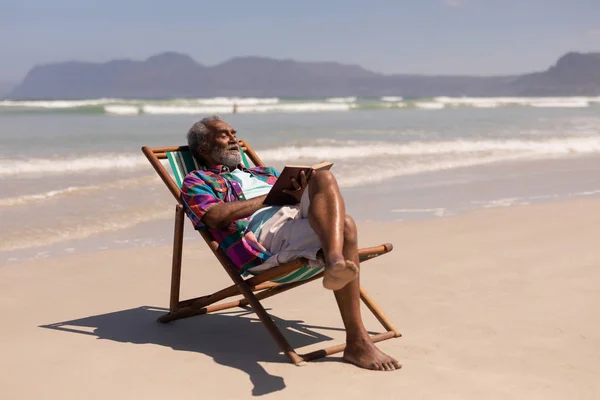 Vue Latérale Homme Âgé Détendre Sur Une Chaise Longue Lecture — Photo