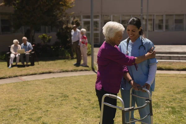 Junge Ärztin Hilft Behinderter Seniorin Sonnigem Tag Garten — Stockfoto