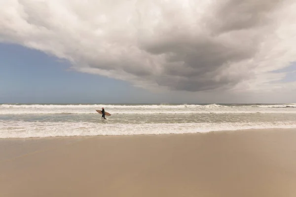 Sahilde Sörf Ile Çalışan Etkin Bir Kadın Kıdemli Önden Görünümü — Stok fotoğraf