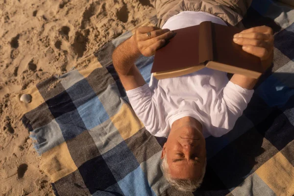 Vista Alta Homem Sênior Ativo Lendo Livro Enquanto Relaxa Cobertor — Fotografia de Stock