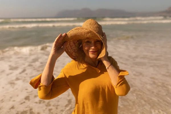 帽子で浜に立ってのアクティブ シニア女性の肖像画 — ストック写真
