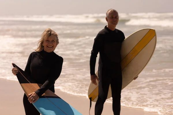 Vooraanzicht Van Senior Paar Met Surfboard Permanent Strand Camera Kijken — Stockfoto