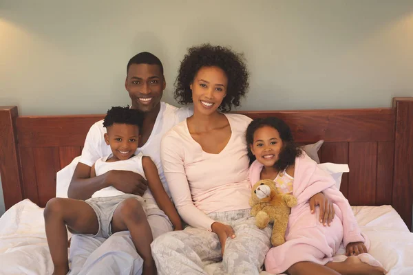 Vista Frontal Feliz Familia Afroamericana Relajándose Cama Mirando Cámara Hogar —  Fotos de Stock