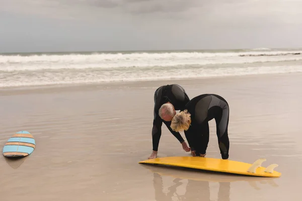 Side View Active Senior Man Helping Senior Woman Wear Surfboard — Stock Photo, Image