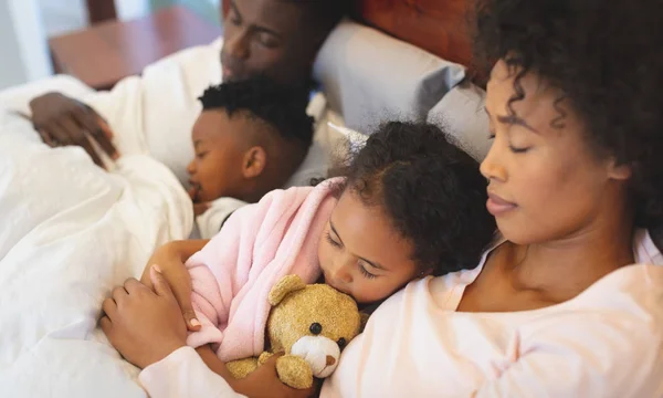 自宅の寝室でベッドで一緒に寝ているアフリカ系アメリカ人の家族のクローズ アップ — ストック写真