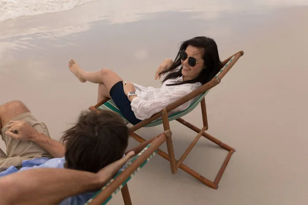 幸福的年轻夫妇在阳光躺椅上放松 在海滩上互相交谈的高角度 — 图库照片