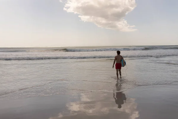 Widok Tyłu Shirtless Surfera Młodych Mężczyzn Desek Surfingowych Chodzenie Plaży — Zdjęcie stockowe