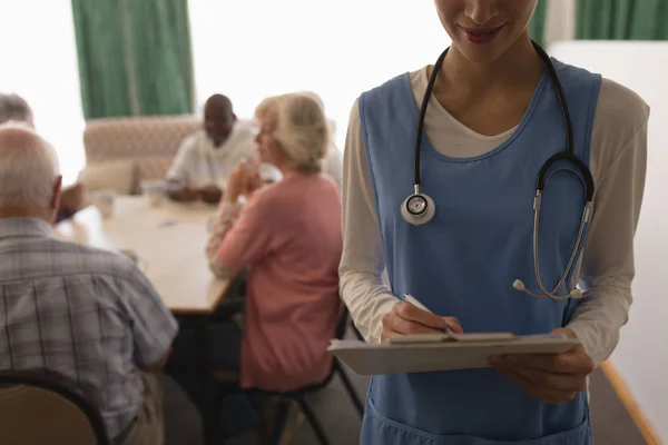 Bir Kadın Doktor Pano Üst Düzey Insanlar Iskambil Bir Masa — Stok fotoğraf