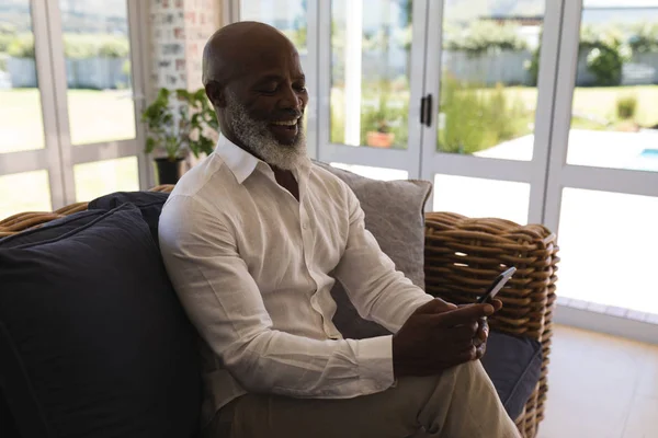 Sidovy Aktiv Senior Mannen Leende Och Med Hjälp Mobiltelefon Vardagsrummet — Stockfoto