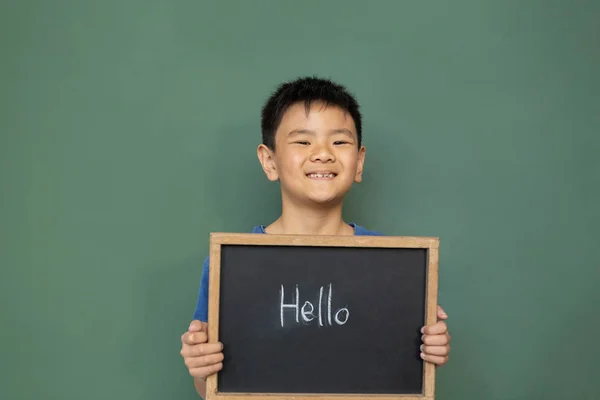 Front View Smiling Asian Schoolboy Standing Holding Hello Slate Classroom — Stock Photo, Image