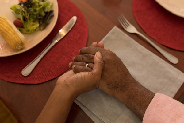 アフリカ系アメリカ人の父と娘のそれぞれの他の手を握って 自宅のダイニング テーブルで食事前に祈りのクローズ アップ — ストック写真