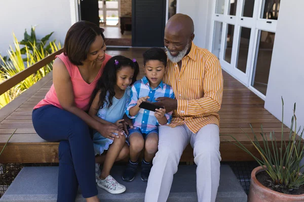 Framifrån Flergenerations African American Family Granska Foto Mobiltelefon Verandan Hemma — Stockfoto