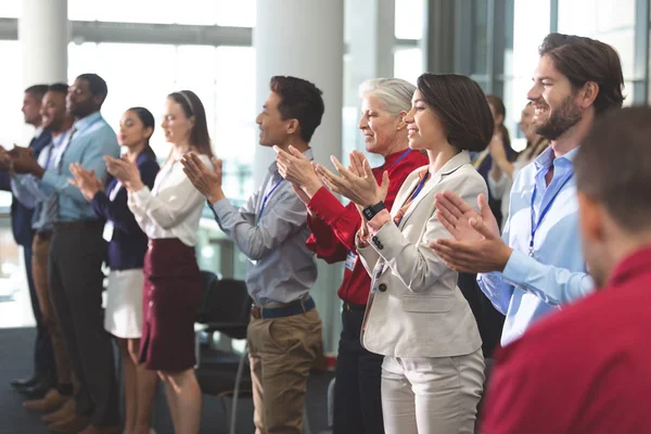 事務所ビルでのビジネス セミナーに立って拍手幸せの多様なビジネス人々 の側面図 — ストック写真