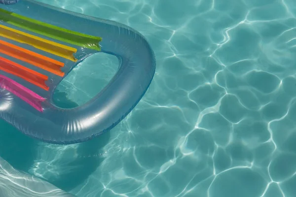 阳光明媚的日子里 充气管漂浮在游泳池里 — 图库照片