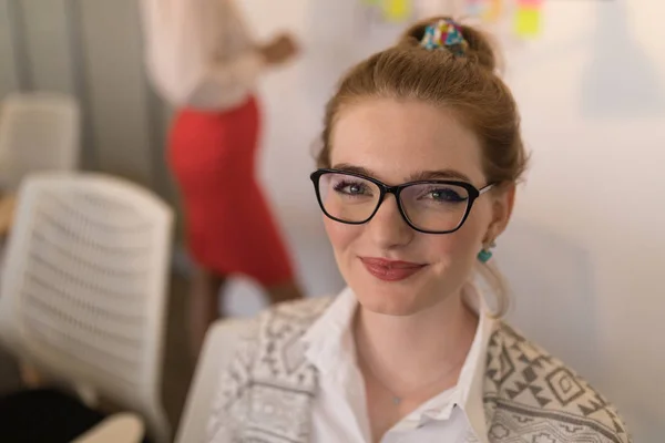 かなり若い白人女性エグゼクティブに笑みを浮かべて近代的なオフィスの肖像画 眼鏡をかけてをいます — ストック写真