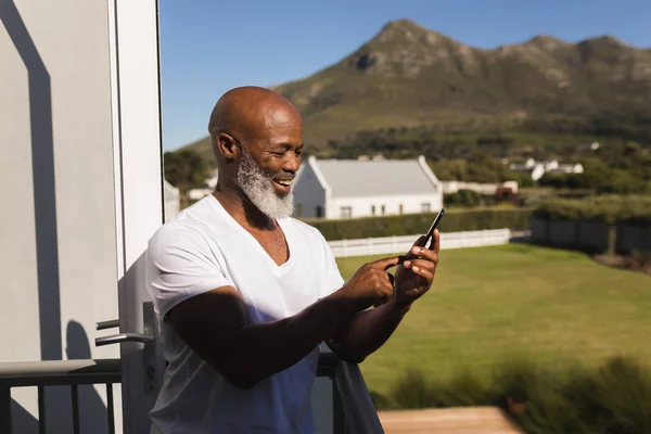 Visão Traseira Homem Afroamericano Sênior Feliz Usando Telefone Celular Varanda — Fotografia de Stock