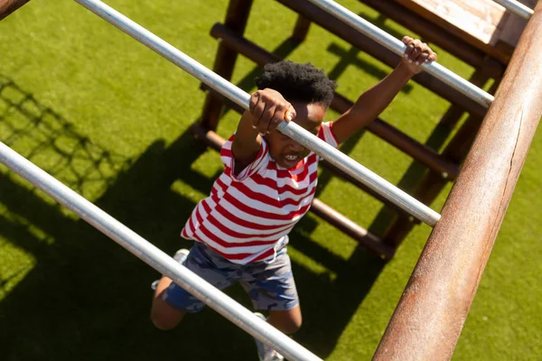 晴れた日に校庭で水平方向のはしごで遊んで集中アフリカ系アメリカ人の少年のハイアングル — ストック写真