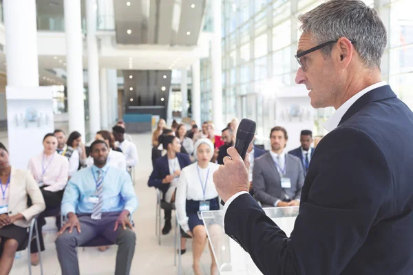 多様なビジネス人々 の会議室ビジネス セミナーでマイクを使って話す白人男性のスピーカーの側面図 — ストック写真