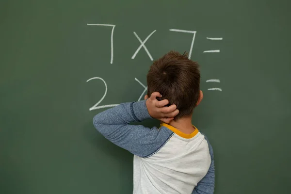 小学校の教室で緑色の基板上の計算を行う白人少年の後姿 — ストック写真