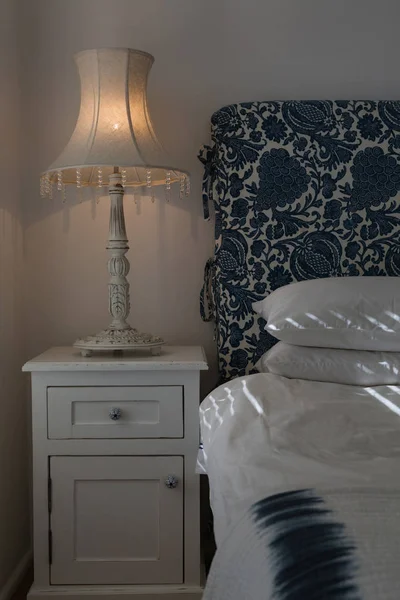 自宅の寝室のベッドの近くにキャビネットに照明テーブル ランプの正面図 — ストック写真