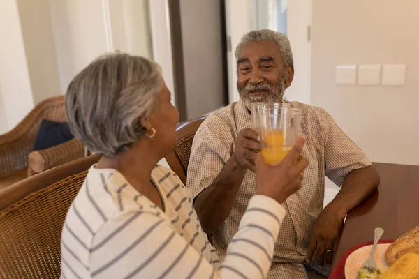 Vista Lateral Pareja Ancianos Afroamericanos Brindando Vasos Jugo Naranja Mientras —  Fotos de Stock