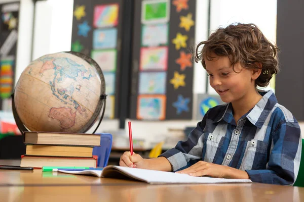 Zijaanzicht Van Een Schooljongen Van Kaukasische Studeren Aan Een Bureau — Stockfoto