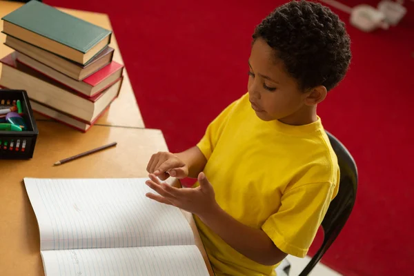 초등학교 교실에서 책상에 손가락으로 귀여운 남학생의 — 스톡 사진