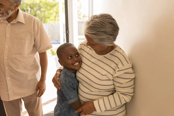 一个快乐的非洲裔美国祖母在家里拥抱她的孙子的正面观点 — 图库照片