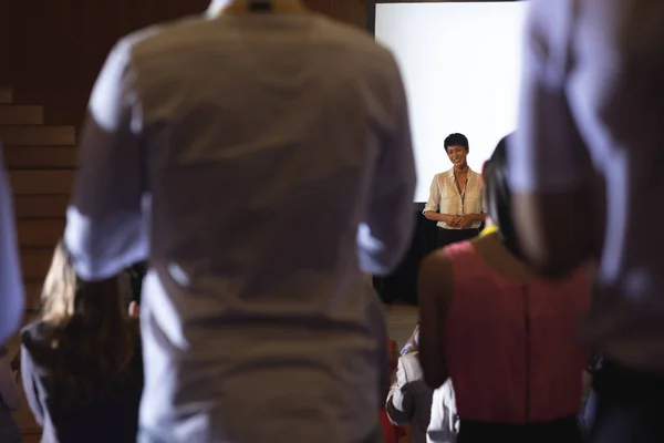 アジアの実業家の講堂でプレゼンテーションを終えた後に拍手混合レース観客の背面図 — ストック写真