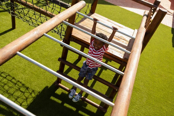 晴れた日に校庭で水平方向のはしごで遊ぶかわいいアフリカ系アメリカ人の少年のハイアングル — ストック写真