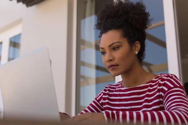 在家里的露台上 一个美丽的非洲裔美国妇女用笔记本电脑看到了她的前面 — 图库照片