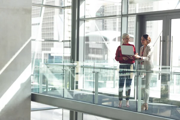 Front View Mixed Race Businesswomen Discussing Laptop Modern Office Building — Stock Photo, Image