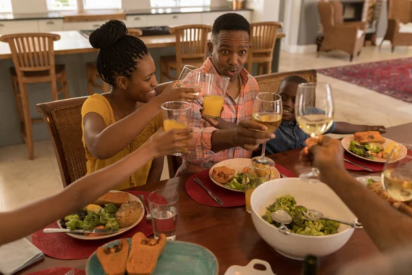 一个多代非裔美国人家庭在家里的餐桌上享用饮料的角度高光大相待 — 图库照片