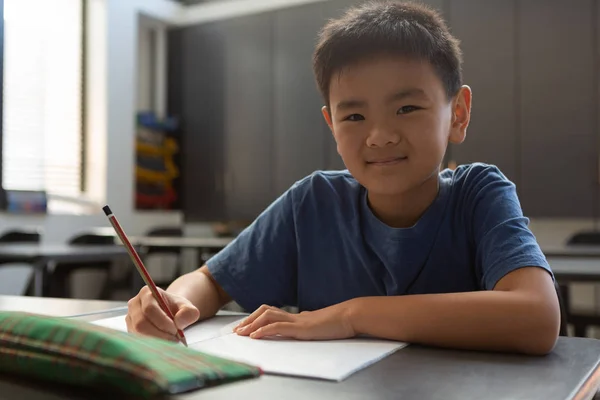 Vue Face Écolier Asiatique Regardant Caméra Tout Écrivant Sur Livre — Photo