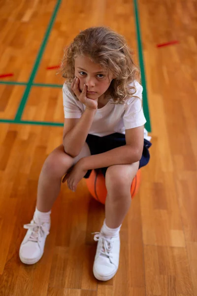 Hoge Hoekmening Van Triest Schooljongen Zittend Basketbal Kijken Naar Camera — Stockfoto