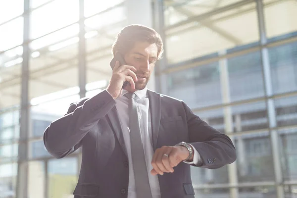 Framifrån Ung Affärsman Kontroll Tid Medan Talar Mobiltelefon Lobbyn Office — Stockfoto