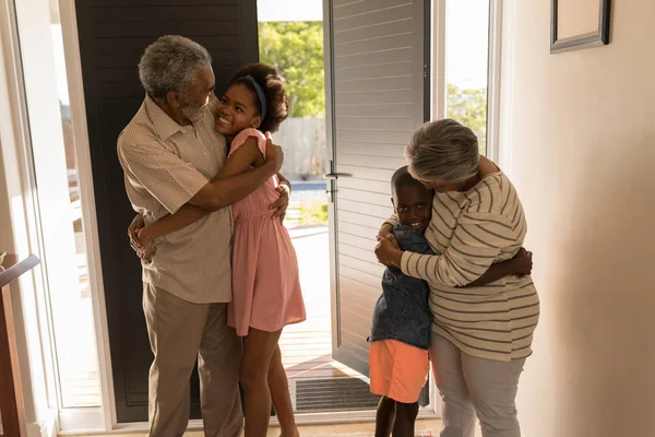 Čelní Pohled Šťastné Afroamerické Prarodiče Doma Objímání Jejich Vnoučata — Stock fotografie