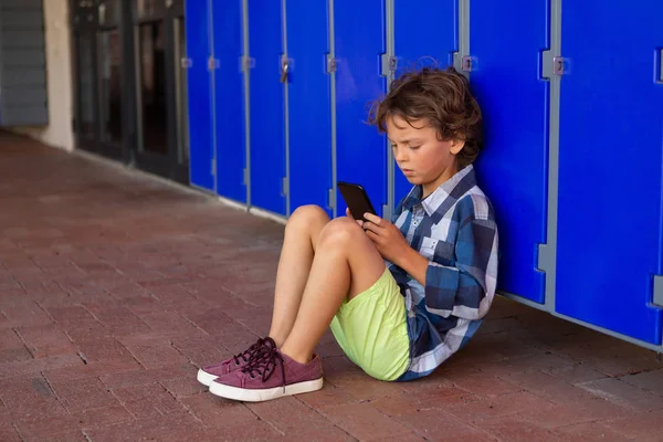 Vooraanzicht Van Een Doordachte Kaukasische Schooljongen Met Behulp Van Mobiele — Stockfoto