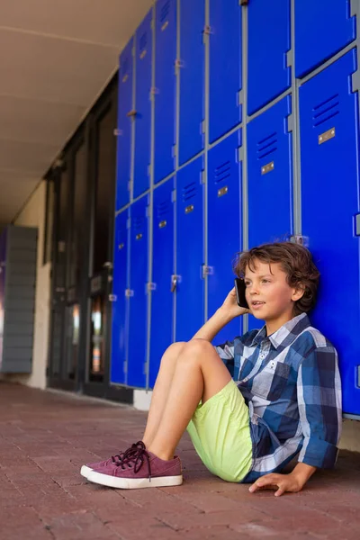 Vooraanzicht Van Een Schattig Kaukasische Schooljongen Praten Mobiele Telefoon Zittend — Stockfoto