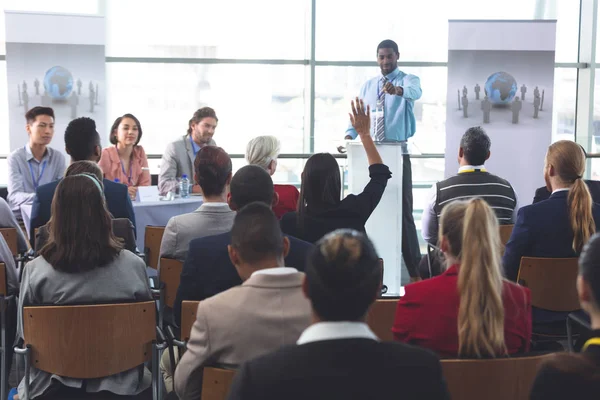 近代的なオフィスビルのビジネス セミナー中に挙手ブルネット混血実業家の後姿 — ストック写真
