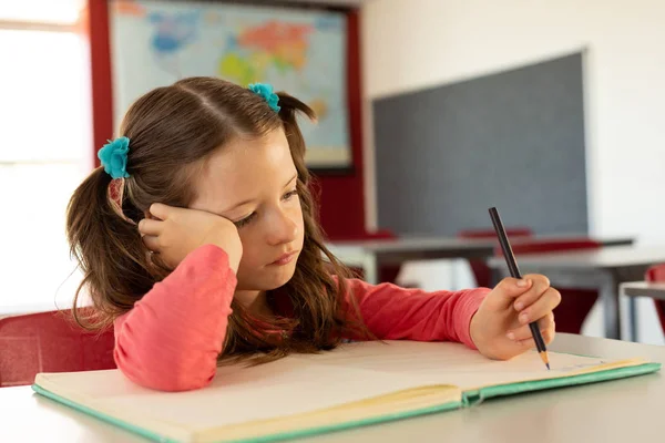 Vista Frontal Triste Chica Caucásica Bonita Escribiendo Cuaderno Aula Escuela — Foto de Stock