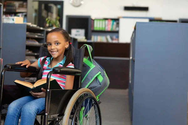 Vooraanzicht Van Een Gelukkig Handicap Gemengd Ras Schoolmeisje Lezen Van — Stockfoto