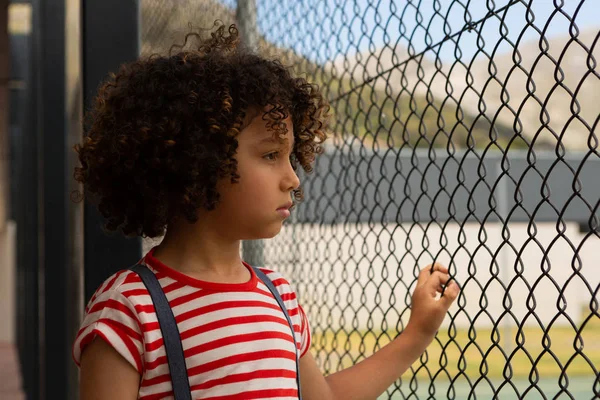 Sidovy Blandad Ras Tankeväckande Skolpojke Står Nära Wire Mesh Staket — Stockfoto