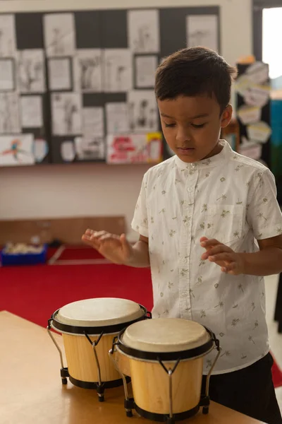 Vista Frontal Estudante Raça Mista Focado Tocando Bongo Uma Sala — Fotografia de Stock