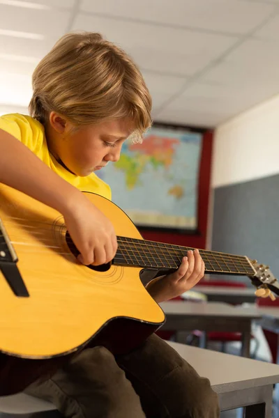 Widok Boczny Chłopiec Kaukaski Gra Gitarze Sali Lekcyjnej Szkole Podstawowej — Zdjęcie stockowe