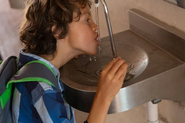 Zijaanzicht Van Een Kaukasische Schooljongen Drinkwater Uit Kraan Gang School — Stockfoto